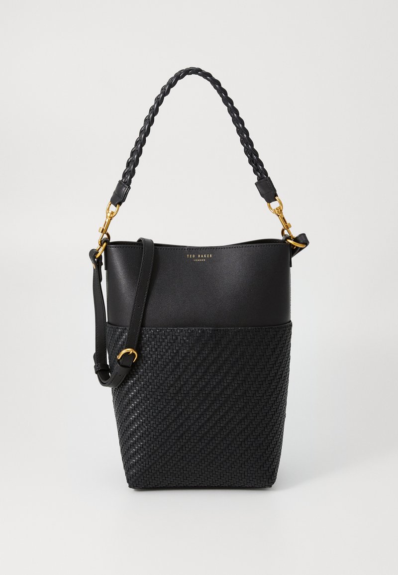 Saco preto de alça trançada, fundo texturizado em tecido entrelaçado e detalhes em dourado; combina materiais lisos e trançados para criar contraste.