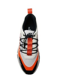 Sport shoe features a predominantly white upper with orange accents, black sole, textured fabric, and a central elastic strap for support.