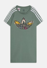 Zielona bawełniana koszulka z dużym, wielokolorowym logo Adidas z wzorem zwierzęcym oraz trzema białymi paskami na ramionach.