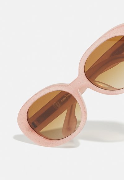 Lunettes de soleil roses pailletées avec des montures ovales surdimensionnées, des verres teintés marron et une branche marron unie comportant un logo gravé à l'intérieur.