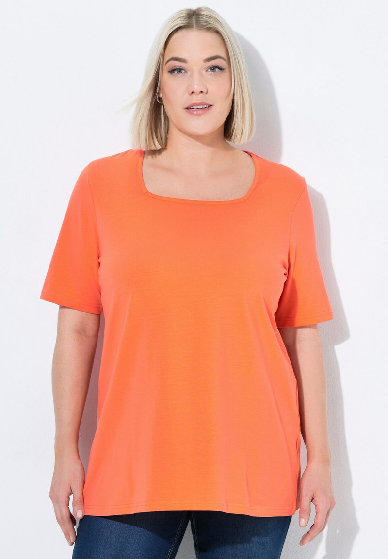 Camiseta de manga corta y escote cuadrado en un vibrante color naranja, confeccionada con una tela suave; cuenta con un corte relajado y aberturas laterales para mayor comodidad.