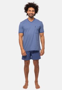 Blå randig t-shirt med V-ringning och ficka, kombinerad med enfärgade blå shorts. Blandning av bomull, korta ärmar, avslappnad passform.