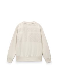 Crème-kleurige sweatshirt met een gestructureerd patroon op de achterkant. Heeft een ronde halslijn, lange mouwen en een ribgebreide zoom en manchetten.