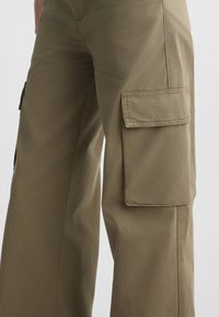 Khaki Cargo-Hosen aus leichtem Stoff, mit zwei großen Seitentaschen mit Klappen, einem lässigen Schnitt und weicher Textur.
