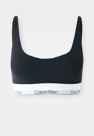 Zwarte Calvin Klein sportbh met brede banden en een witte elastische band met de merknaam in zwarte letters.