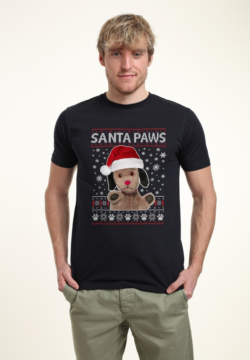 Svart bomulls T-shirt med en tecknad hund som bär en tomteluv. Designen inkluderar snöflingor och tassavtryck i rött och vitt.