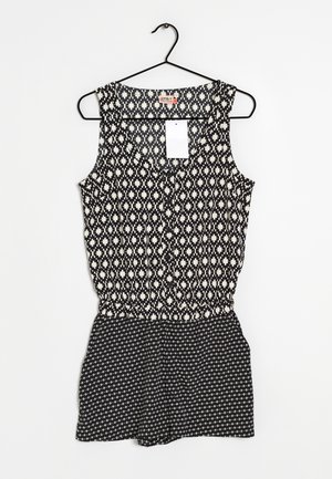 Combinaison sans manches noir et blanc présentant un motif géométrique sur le haut, avec une taille froncée et une partie inférieure en short texturée et à motif.