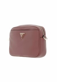 Bolso cruzado de imitación cuero color burdeos con cierre de cremallera, textura en relieve y un acento de logotipo dorado en forma de triángulo en el frente.