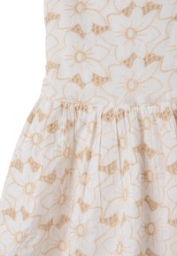 Vestido de tela blanca con bordado floral texturizado en beige claro, con falda Acampanada y un acabado sutil y ligero.