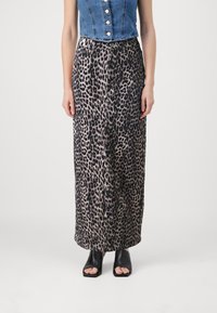 Falda larga de tela con estampado de leopardo, con una textura suave y una cintura con cordón. Llevada con sandalias negras de tacón bloque y puntera abierta.