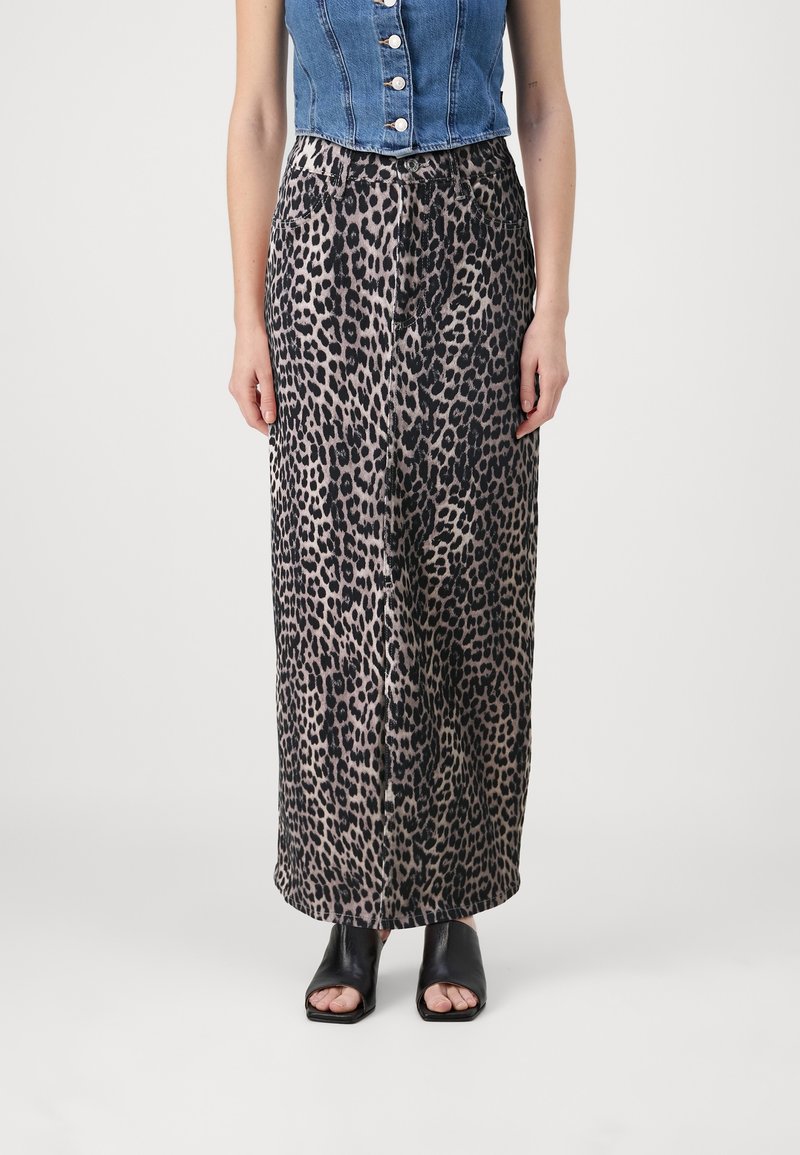 Falda larga de tela con estampado de leopardo, con una textura suave y una cintura con cordón. Llevada con sandalias negras de tacón bloque y puntera abierta.