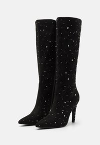 Stivali neri in suede al ginocchio con punta appuntita e tacco a spillo, impreziositi da strass argentati sparsi e chiusura con cerniera laterale.