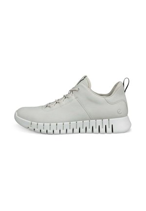 Baskets de sport gris clair avec une tige texturée, fermeture à lacets et une semelle blanche épaisse présentant un motif en vagues. Petite languette noire à l'arrière.