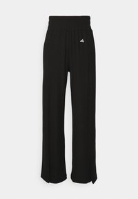 Schwarze Sporthose mit weitem Bein, ausgestattet mit einem elastischen Bund und einem kleinen weißen Logodetail auf der linken Seite.