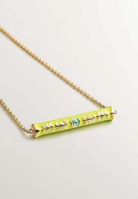 Collar de cadena de oro con un vibrante colgante cilíndrico verde que presenta detalles en relieve de flores y un acento azul.