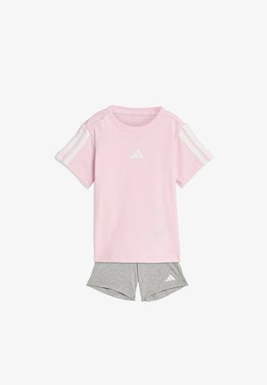 Light pink short-sleeve T-shirt with white shoulder stripes and logo; paired with gray athletic shorts featuring a logo on the hem.