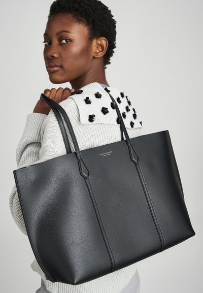 Sac en cuir noir avec une finition texturée, présentant un design simple, des poignées allongées et un branding doré discret.