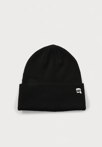 Gorro de punto negro con un dobladillo y un pequeño logo bordado que presenta una cara con gafas de sol en el lateral. Textura suave.