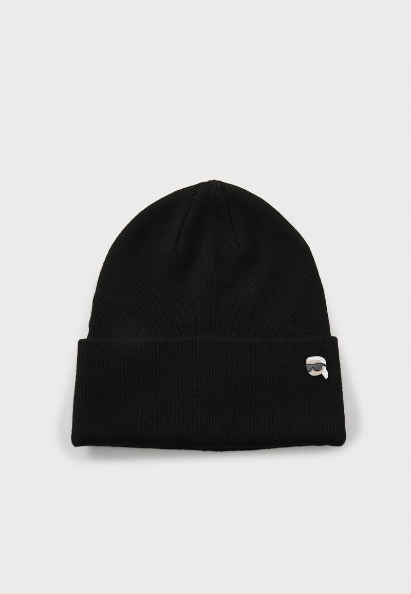 Gorro de punto negro con un dobladillo y un pequeño logo bordado que presenta una cara con gafas de sol en el lateral. Textura suave.