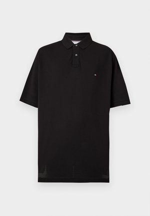 Schwarzes kurzärmeliges Poloshirt mit zwei Knöpfen und kleinem rot-weiß-blauem Logo auf der linken Brust vor einfarbigem Hintergrund.