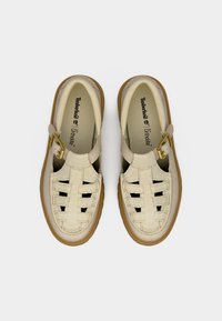 Μπεζ δερμάτινα πλεκτά σανδάλια με κούμπωμα και μαλακές εσωτερικές σόλες Ortholite, σε προβολή από πάνω σε λευκό φόντο.