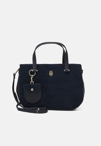 Borsa a mano blu navy realizzata in suede e pelle, con tasca frontale, hardware dorato, doppi manici e tracolla removibile.