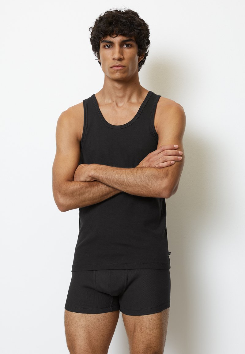 Schwarzes Tanktop und passende Boxer aus weichem Baumwollstoff. Das Tanktop hat einen runden Ausschnitt, während die Boxer eine enge Passform aufweisen.