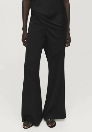 Pantaloni neri a gamba larga con design drappeggiato. Realizzati in un tessuto morbido, presentano una superficie liscia e una vita alta. Accentuati da elementi hardware minimal.