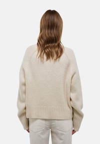 Pull crème oversize en tricot doux, avec des poignets et un ourlet côtelés, des épaules tombantes et un dos décontracté.