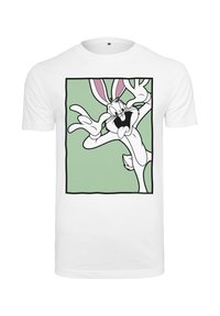 Fehér póló zöld négyzettel, amin egy rajzfilm nyúl játékos arckifejezéssel és a szemei közelében tartott kezekkel látható.