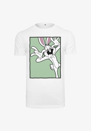 Biele tričko so zeleným štvorcom, na ktorom je kreslený zajac s hravou tvárou a rukami blízko pri očiach.