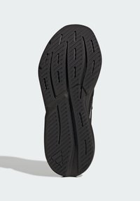 Czarna gumowa podeszwa buta z teksturowanym bieżnikiem i głębokimi rowkami zapewniającymi przyczepność. Posiada lekko wygięty obcas i wzmocnione krawędzie.