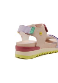 Sandale multicolore avec une tige en synthétique beige, des sangles ajustables et une semelle texturée. Présente des accents roses, violets et verts.
