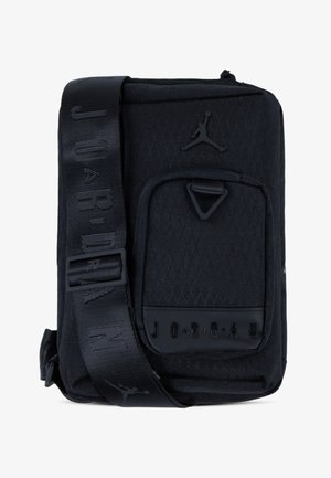 Bolsa transversal em tecido preto com um padrão geométrico, apresentando um bolso frontal, alça resistente e detalhes de logotipo em relevo.