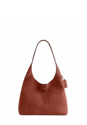 Braune Wildleder-Schultertasche mit einem Tragegriff, kleinem goldenen Logo vorne und angebrachtem Lederanhänger an einer goldenen Kette.
