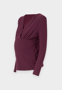 Kismama felső mély burgundy színben, hosszú ujjal, V-nyakkivágással, és ráncolt részletekkel a mellen és az oldalakon, puha anyagból készült.