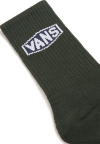 Green ribbed sock featuring a white and blue "VANS" logo stitched on the side. Made of soft fabric; standard crew sock length.