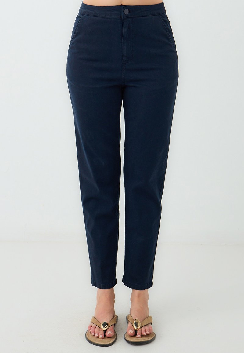 Pantaloni blu navy a vita alta con design affusolato, realizzati in un tessuto misto cotone. Presentano una chiusura con bottone fronte e tasche laterali.