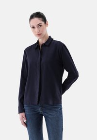 Navy blue long-sleeve shirt with a button-down collar, featuring a frayed edge along the front opening and a smooth texture.