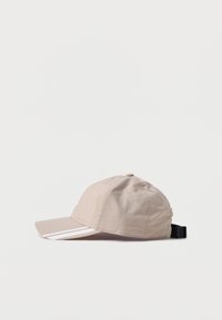 Bežna bombažna kapa s ukrivljenim robom, ima bele črte, majhne prezračevalne luknje in nastavljiv črn pas zadaj.