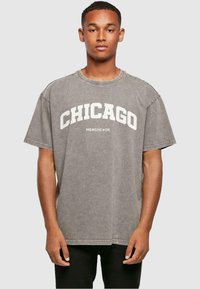 Grijze oversized t-shirt met "CHICAGO" in het wit gedrukt over de borst, voorzien van een ronde hals en korte mouwen, gemaakt van zachte katoen.