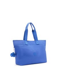 Borsa tote blu con due manici, realizzata in tessuto, caratterizzata da un logo rotondo e un charm blu peloso attaccato da un piccolo gancio metallico.