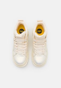 Høye sneakers i lys kremfarge, med en blank, glatt finish, snøring, polstrede krager og en gul innside med logo.