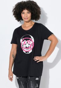 Camiseta negra con un gráfico de calavera blanca rodeada por un círculo rosa, de manga corta y corte relajado. Material de mezcla de algodón.