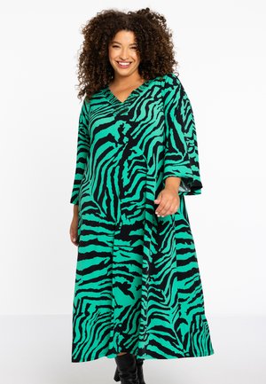 Robe maxi avec un décolleté en V, des manches évasées et un motif zèbre vert et noir. Fabriquée en tissu doux avec une coupe décontractée.