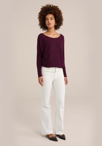 Violeta ribota džemperis ar plašu kakla izgriezumu, kombinēts ar baltām plestām džinsām un melnām uzgaliem dzīvokļiem. Tīras līnijas, gludas tekstūras.