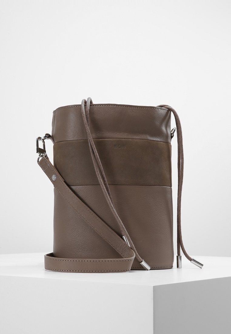 Borsa a secchiello in pelle marrone con un design bicolore; presenta una tracolla rimovibile e hardware in tonalità argento per la chiusura. Finitura testurizzata.