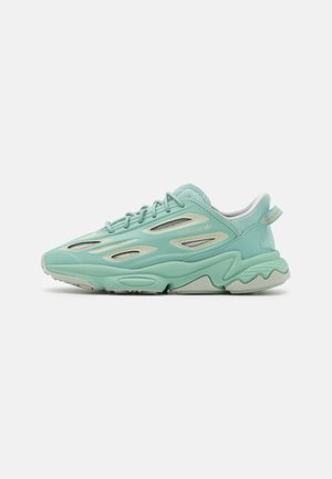 Baskets Adidas bleu sarcelle clair avec des détails en mesh ventilé, semelle épaisse sculptée, design à lacets et languette au talon sur fond blanc.