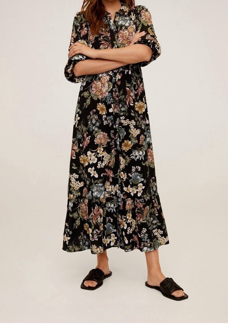 Robe maxi noire à fleurs avec boutonnage sur le devant, manches courtes retroussées et ourlet volanté ; présente de grandes fleurs multicolores et une coupe ample.