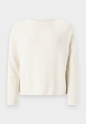Pull en tricot couleur crème à manches longues avec col rond et discrètes fentes latérales, présenté sur un fond gris clair.